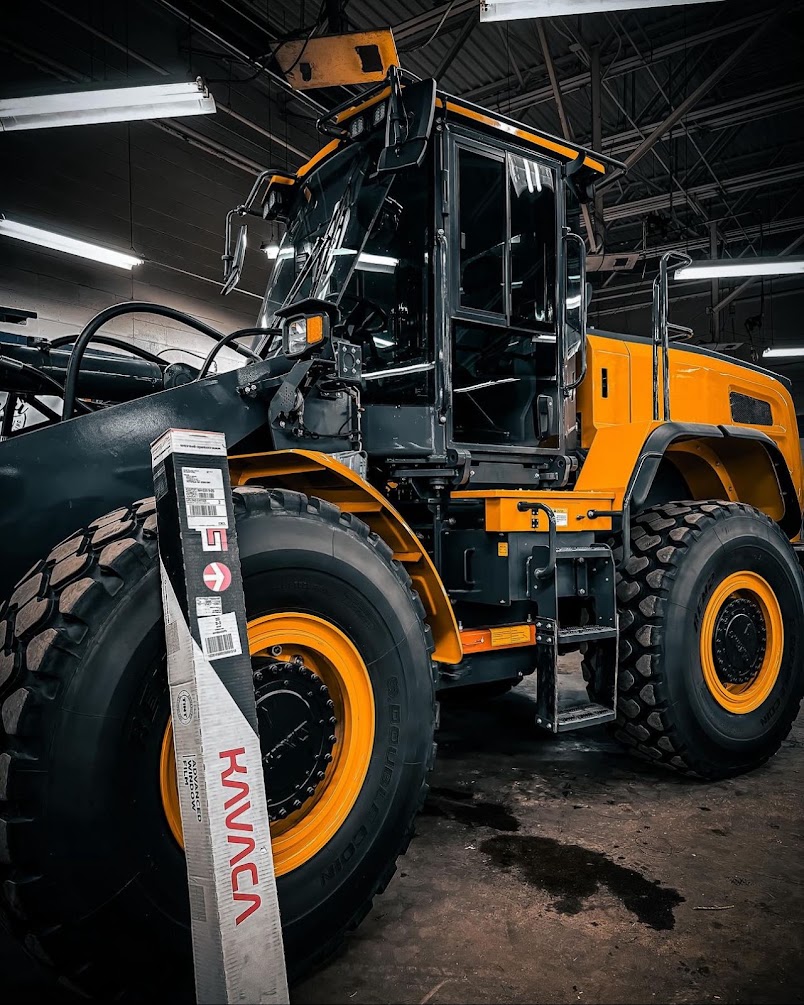 Wheel loader cab glass prepped for heat-rejection film ahead of a summer season.