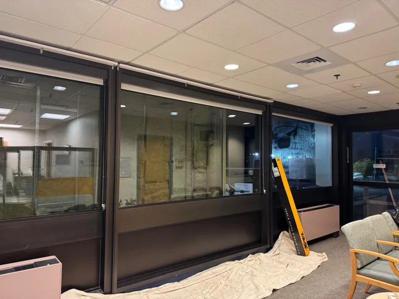 Office waiting area with clear glass partitions before frosted privacy film was installed.