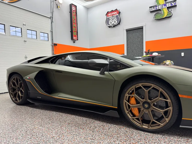Side profile of a green Lamborghini Aventador SVJ with freshly tinted side glass.
